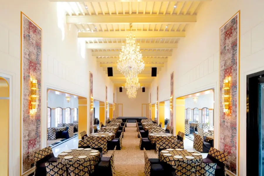 View of elegant banquet hall at The Earth Amritsar with grand chandeliers and regal interiors.
