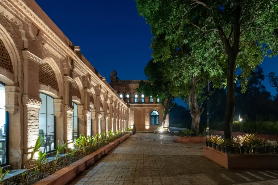 Heritage facade of The Earth Amritsar illuminated at night, showcasing timeless Mughal-inspired architecture.